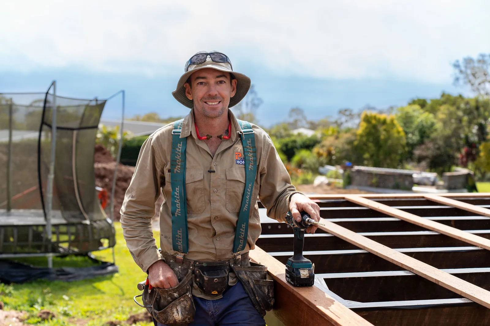 A deck builder using the NOGBOSS 14g wood drill assembly on a timber deck frame